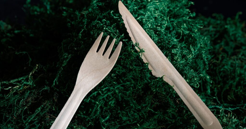 wood cutlery, a fork and knife, on a bed of green moss