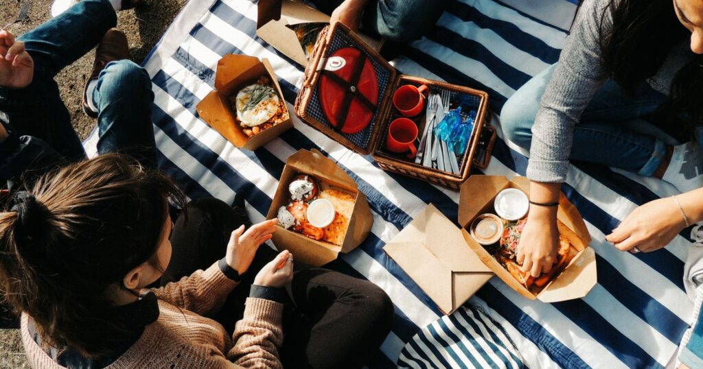 women having a picnic with food in takeout containers, restaurant sustainability