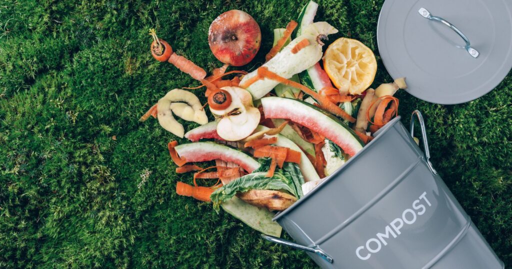 Home composting bin with foodwaste falling out onto grass
