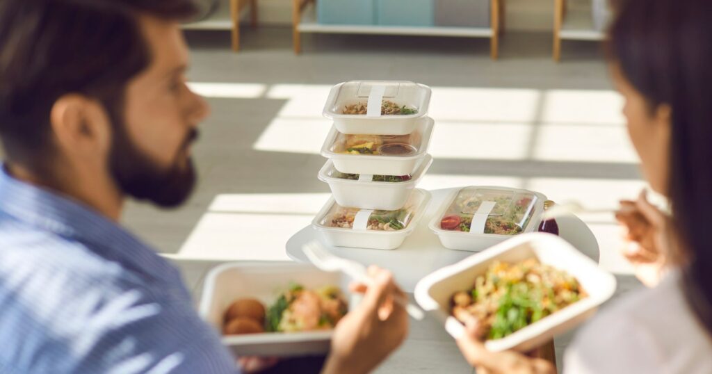 People eating lunch out of reusable takeout container