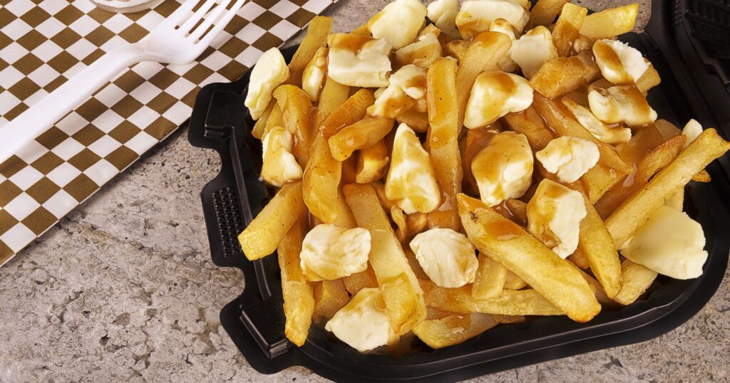 poutine in a black plastic reusable takeout container