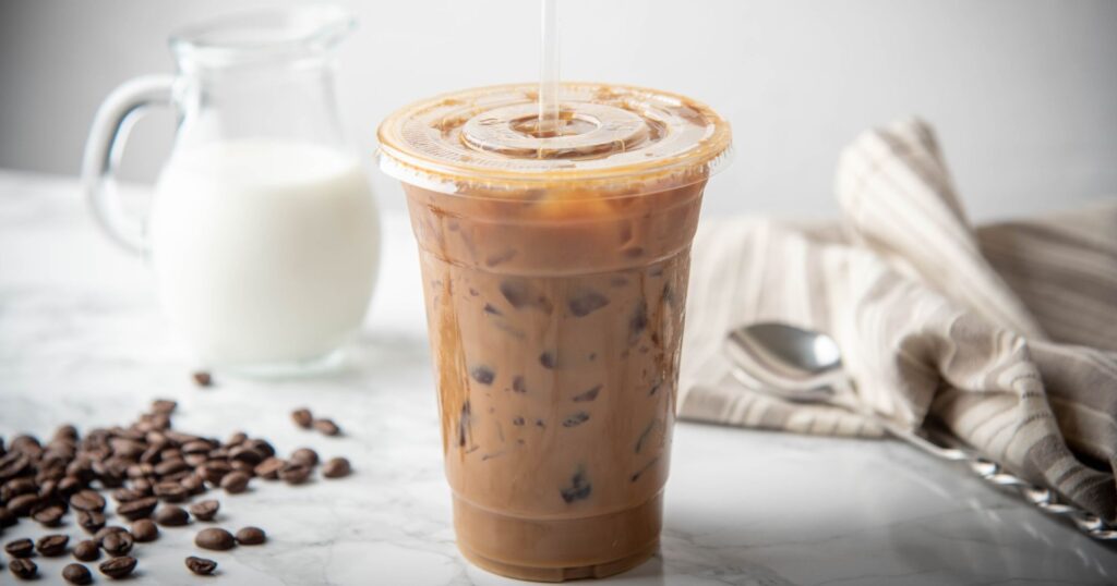 A single-use plastic to-go iced coffee in front of a white background