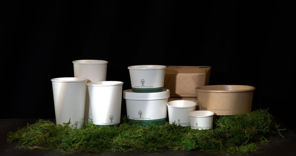group of aqueous-lined takeout containers on moss with black background